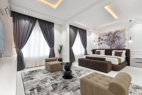 a bedroom with a bed and a couch and chairs at Casa Aurelia Penthouse in Lekki