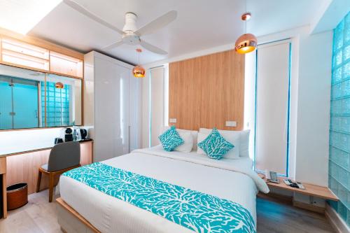 a bedroom with a large bed and a kitchen at Hotel Star Shell in Hulhumale