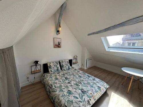 a bedroom with a bed and a table and a window at La cachette d Auxerre - Centre Ville in Auxerre