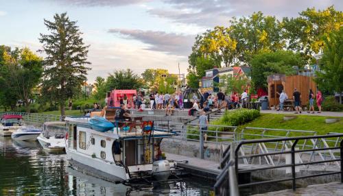 a group of people standing on a dock next to a boat at Holiday Inn St-Jean-sur-Richelieu Congrès by IHG in Saint-Jean-sur-Richelieu