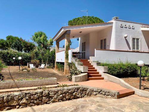 ein weißes Haus mit einer Steinmauer und einer Treppe in der Unterkunft Villa Oleandera a Polignano a Mare in Polignano a Mare