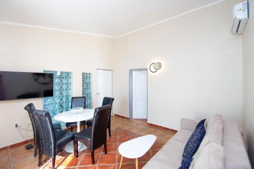 a living room with a couch and a table and chairs at ACIKA apartments in Rafailovici