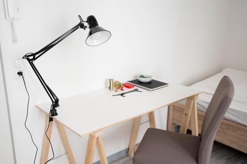 a white desk with a lamp and a chair at Altstadt Suite in Weimar