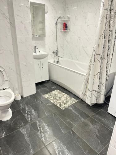 a bathroom with a tub and a toilet and a sink at Appartament Karja 26A/10 in Narva-Jõesuu