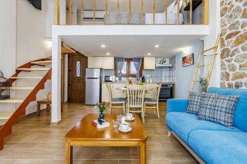 Una sala de estar con un sofá azul y una mesa. en SUN NEST Loft, en Skopelos Town