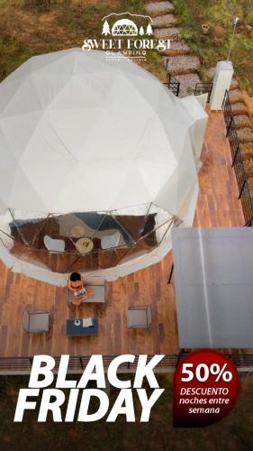 an aerial view of a black friday event with a white umbrella at Sweet Forest Glamping in Sucre