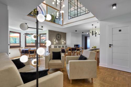 a living room with chairs and a dining room at Leśny Dworek - Pokoje & Apartamenty in Białka Tatrzanska