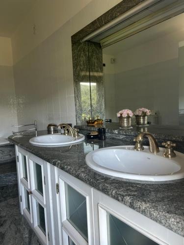 a bathroom with two sinks and a large mirror at Cascina Ciosse B&B in Grognardo