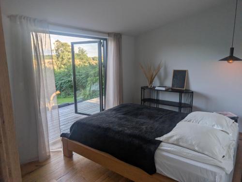 a bedroom with a bed and a sliding glass door at Nordic Designer Summerhouse - With a fantastic view in Vejby