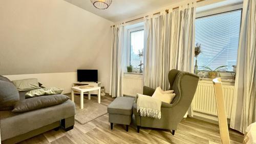 Ferienwohnung Heimathafen في لوبيك: غرفة معيشة مع أريكة وكرسي