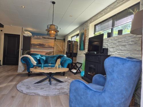 a living room with blue furniture and a fireplace at B&B Aquamarijn Katwijk in Katwijk aan Zee