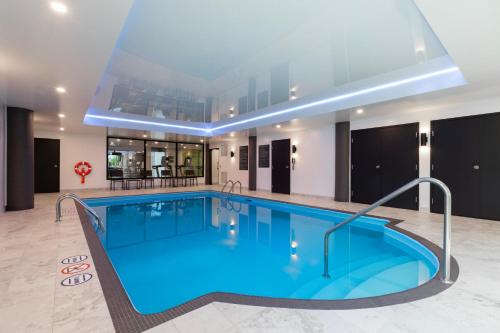 a swimming pool in a hotel room with a large building at Holiday Inn St-Jean-sur-Richelieu Congrès by IHG in Saint-Jean-sur-Richelieu