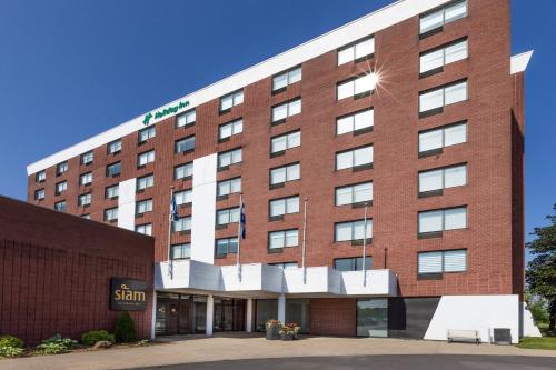 a red brick building with a sign on it at Holiday Inn St-Jean-sur-Richelieu Congrès by IHG in Saint-Jean-sur-Richelieu