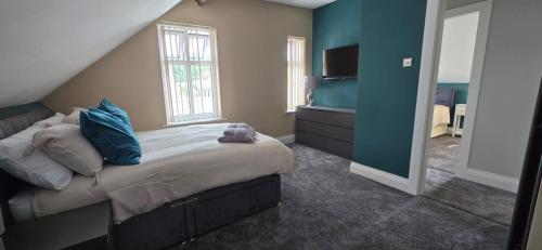 a bedroom with a large bed with blue pillows at Stylish 4 bed in Central Conwy in Conwy