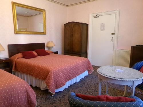 a hotel room with two beds and a mirror at Averon Guest House in Edinburgh