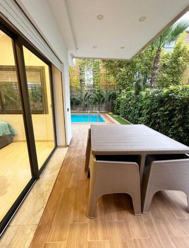 a patio with a table and chairs and a pool at appartement de luxe au rez de jardin avec piscine privative in Tamaris