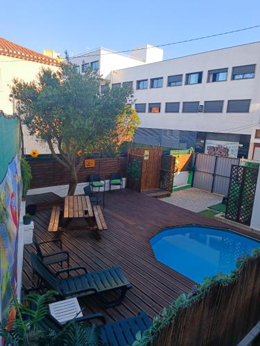 a deck with chairs and a swimming pool at Happy Day Beach House in Costa da Caparica