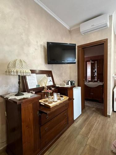 a room with a desk with a lamp and a refrigerator at B&B Corvara in Nettuno