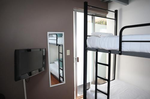 a room with two bunk beds and a television at Habitación privada con terraza en Polanco. in Mexico City