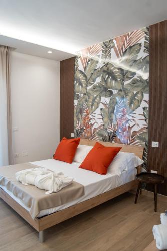 a bedroom with a large bed with red pillows at Viroga Suite Apartments in Castel Volturno