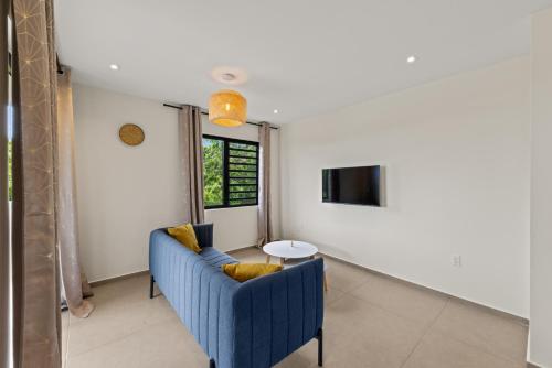 a living room with a blue couch and a table at Vista Papaya Suites in Westpunt
