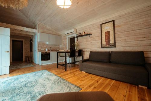 a living room with a couch and a kitchen at Akmenos Villas & Bungalow in Bražuolė