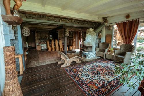 a living room with a fireplace on a wooden floor at Akmenos Villas & Bungalow in Bražuolė