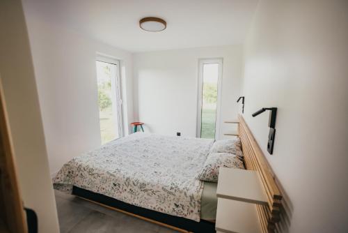 a white bedroom with a bed and a window at Śliwkowy Sad-Plum Orchard-Jura in Mirów