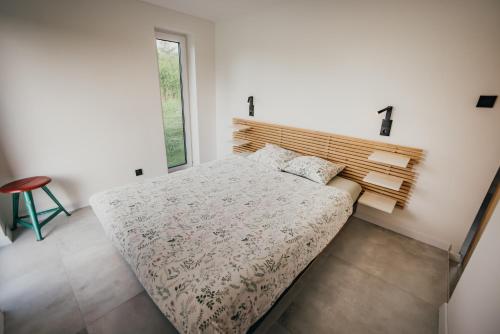 a bedroom with a large bed with a wooden headboard at Śliwkowy Sad-Plum Orchard-Jura in Mirów