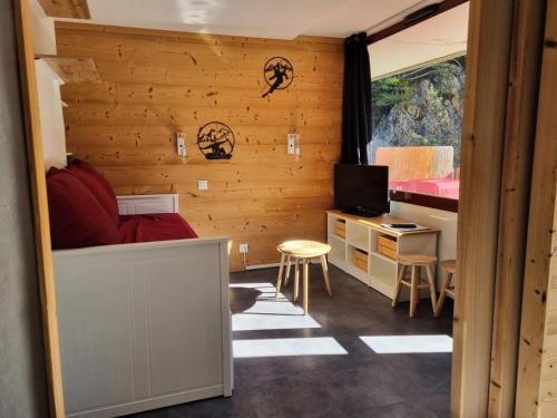 Cette chambre comprend un lit et un bureau avec une télévision. dans l'établissement Résidence Saint Jacques A - Studio pour 4 Personnes 26, à Mâcot La Plagne