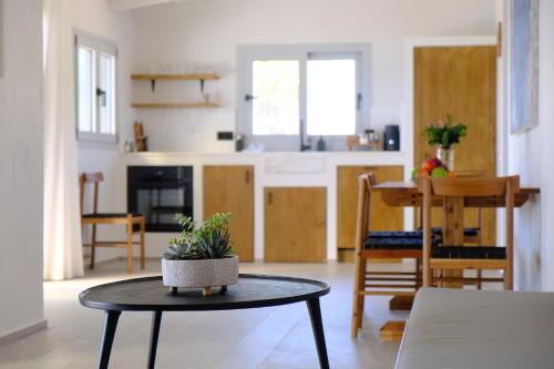 a living room with a table and a kitchen at Evia Bay Suites and Retreats in Edipsos