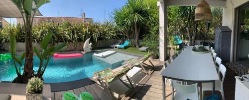 ein Swimmingpool mit Tisch und Stühlen im Garten in der Unterkunft Villa Marina in Sanary-sur-Mer