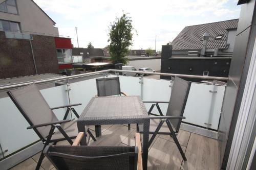 a table and two chairs on a balcony at Barrierearme Ferienwohnung in Jever