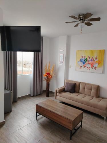 a living room with a couch and a coffee table at Casa Yuraq Hotel Boutique in Chincha Alta