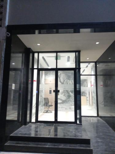 an open glass door of a building with a chair at Stunning studio with balcony close to metro in Dubai