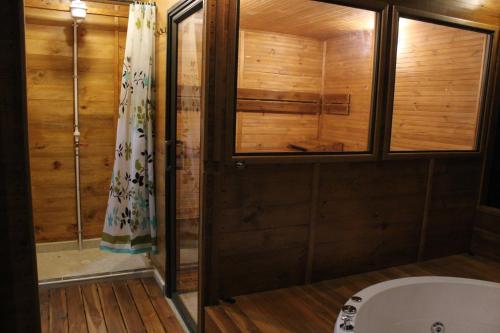 a bathroom with a shower and a bath tub at Cielo Verde Wood House 