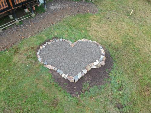a stone heart on the ground in the grass at Cielo Verde Wood House 