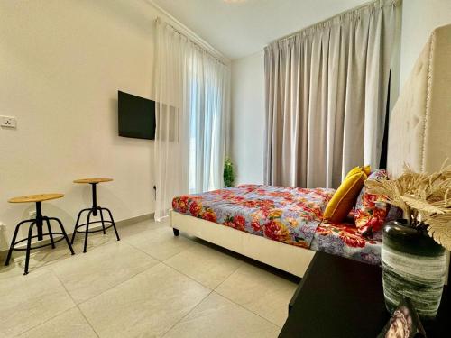 a bedroom with a bed and a window and a table at Stunning studio with balcony close to metro in Dubai