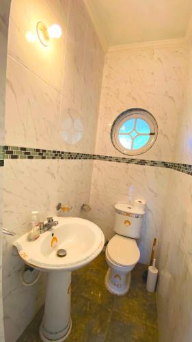 a small bathroom with a toilet and a sink at Ocean JB Tower Isle in Tower Isle