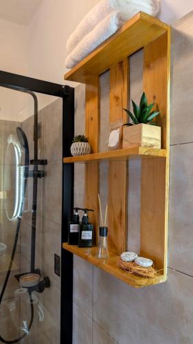 a wooden shelf above a shower in a bathroom at La Maison de Canelya in Cotonou