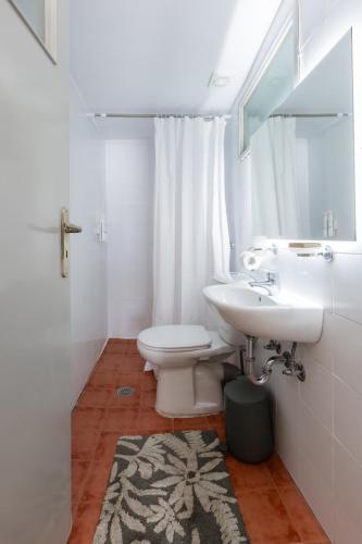 a bathroom with a sink and a toilet and a mirror at Arsenale di Nafplio Rooms in Nafplio