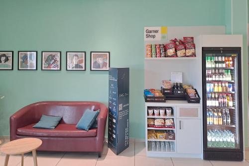 a store with a leather couch next to a refrigerator at Garner Hotel Cottbus Süd by IHG in Cottbus