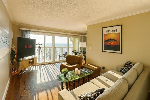 a living room with a couch and a tv at Ocean Haven Beachfront Getaway by Redondo Pier in Redondo Beach