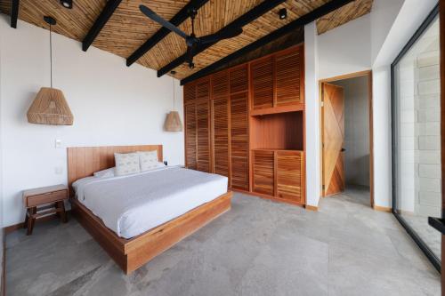 a bedroom with a bed and a wooden wall at Aviva, brand new designer luxury villa in Vichayito