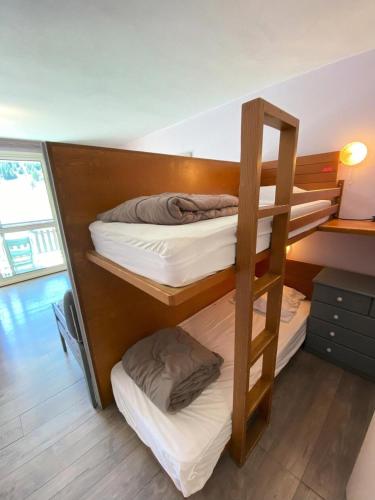 une chambre avec trois lits superposés dans une pièce dans l'établissement Résidence Le Bois D'aurouze - Studio pour 4 Personnes MAE-7764, à Saint-Étienne-en-Dévoluy