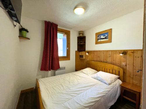 - une petite chambre avec un lit et un rideau rouge dans l'établissement Résidence Courmayeur - Appartement 6 personnes ski aux pieds aux Ménuires MAE-3874, aux Menuires