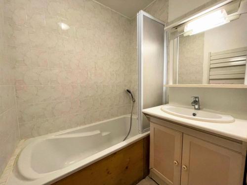 une salle de bain avec une baignoire et un lavabo dans l'établissement Résidence Courmayeur - Appartement 6 personnes ski aux pieds aux Ménuires MAE-3874, aux Menuires