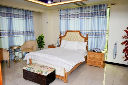 a bedroom with a large bed with blue curtains at ROOST Hotel and Restaurant in Bāgh