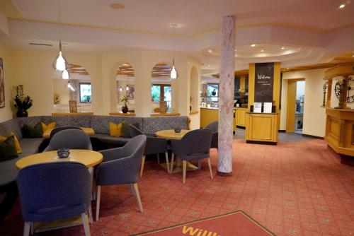 ein Restaurant mit Tischen und Stühlen und eine Bar in der Unterkunft Hotel Garni Rifflsee in Sankt Leonhard im Pitztal