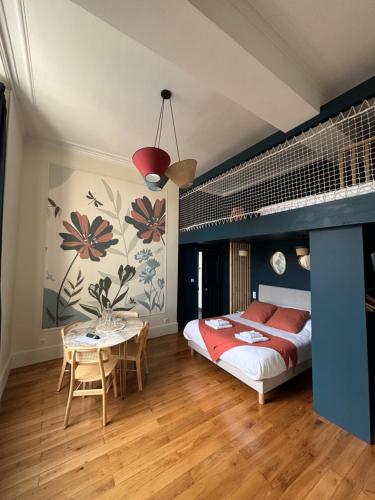 a bedroom with a bed and a table in it at La Parenthèse Fléchoise, Chambre Raphaël in La Flèche